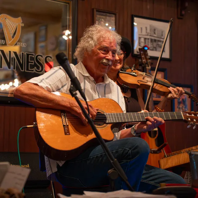 Wayne Rogers playing guitar and banjo