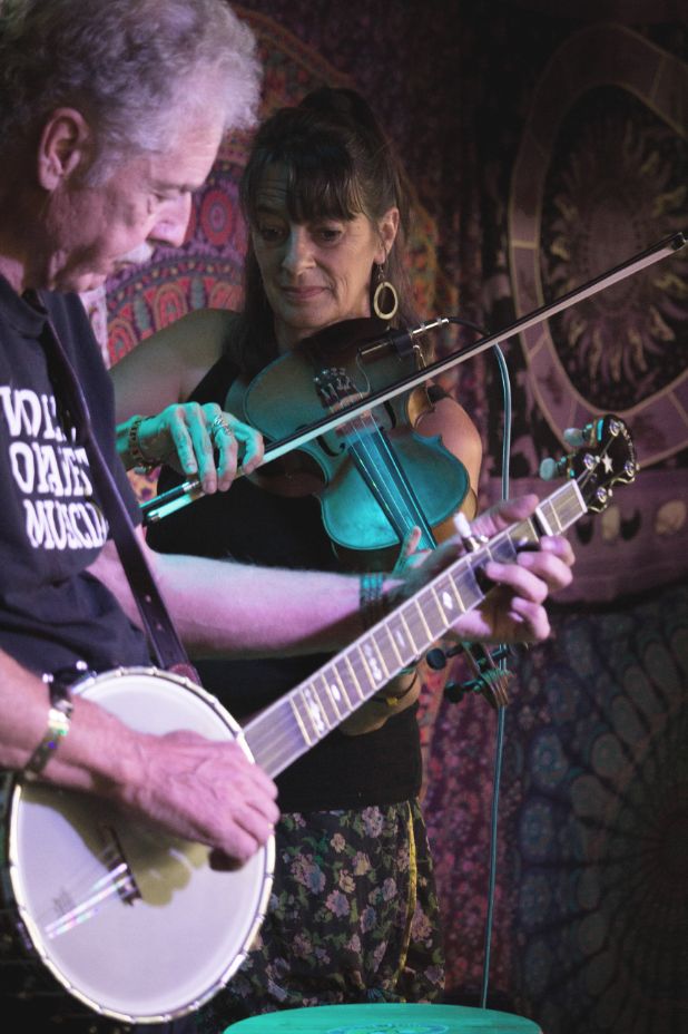 A closeup of the banjo and fiddle being played